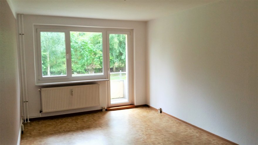 zeigt Wohnraum mit Balkonzugang